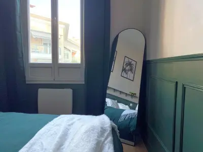 a bedroom with a mirror and a bed and a window at Charmant 2P avec Balcon, Proche Centre in Cannes