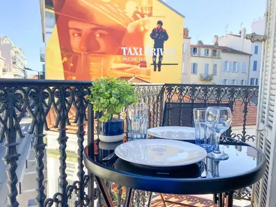 a table with plates and glasses on a balcony at Charmant 2P avec Balcon, Proche Centre in Cannes