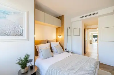 a bedroom with a white bed with a picture on the wall at REF 1981 - Cannes sea view apartment Cannes Palm Beach in Cannes
