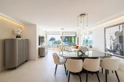 a dining room with a table and white chairs at REF 1981 - Cannes sea view apartment Cannes Palm Beach in Cannes
