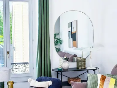 a living room with a mirror and a chair at Grand appartement rénové - Jardin et Parking - CZ in Cannes