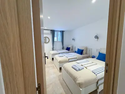 a room with three beds with blue pillows at Grand appartement rénové - Jardin et Parking - CZ in Cannes