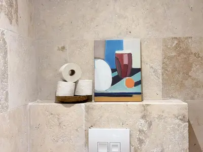 a pile of toilet paper and a painting on a wall at Grand appartement rénové - Jardin et Parking - CZ in Cannes