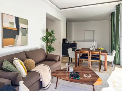 a living room with a couch and a table at Grand appartement rénové - Jardin et Parking - CZ in Cannes