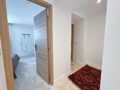 a door leading into a hallway with a rug at Grand appartement rénové - Jardin et Parking - CZ in Cannes