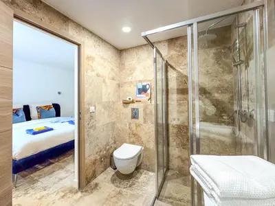 a bathroom with a shower and a toilet and a bed at Bel appartement rénové - Jardin et Parking - DA in Cannes
