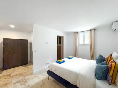 a bedroom with a large bed and a couch at Bel appartement rénové - Jardin et Parking - DA in Cannes