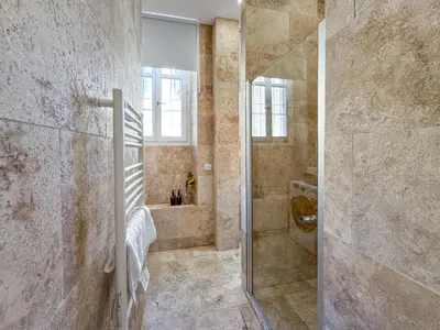 a bathroom with a walk in shower and a glass door at Bel appartement rénové - Jardin et Parking - DA in Cannes