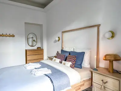 a bedroom with a large bed with blue pillows at Bel appartement rénové - Jardin et Parking - DA in Cannes