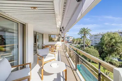 a balcony with a table and chairs and a pool at REF 1980 - Cannes palm Beach sea view in Cannes