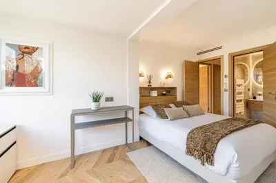 a bedroom with a large white bed and wooden floors at REF 1980 - Cannes palm Beach sea view in Cannes