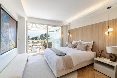 a bedroom with a large bed and a balcony at REF 1980 - Cannes palm Beach sea view in Cannes