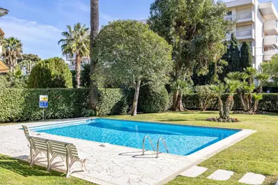 a swimming pool in a yard with chairs and trees at REF 1980 - Cannes palm Beach sea view in Cannes