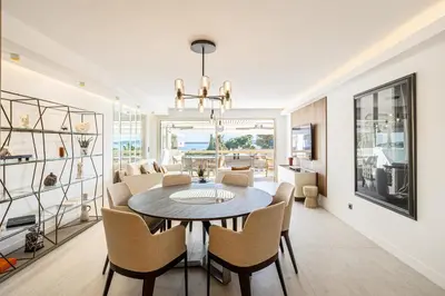a dining room and living room with a table and chairs at REF 1980 - Cannes palm Beach sea view in Cannes