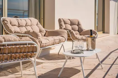 a group of chairs and a table with a bottle of wine at Appartement vue mer panoramique in Cannes