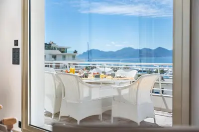 a balcony with a table and chairs on a ship at Appartement vue mer panoramique in Cannes