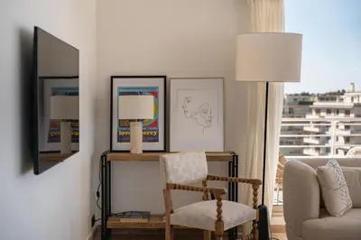 a living room with a chair and a lamp at Appartement vue mer panoramique in Cannes