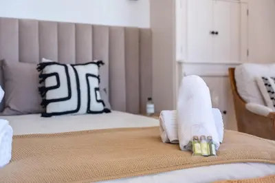 a bed with white sheets and pillows on it at Appartement vue mer panoramique in Cannes