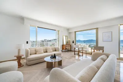 a living room with white furniture and large windows at Appartement vue mer panoramique in Cannes
