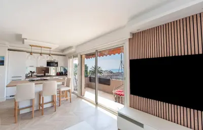 a kitchen and living room with a large screen tv at Les YUCCAS - 2 pièces Suquet Parking Vue Mer pour 4 personnes in Cannes