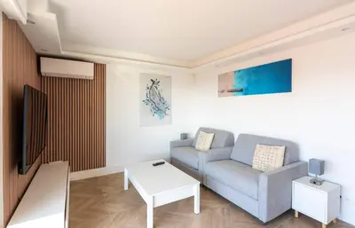 a living room with a couch and a table at Les YUCCAS - 2 pièces Suquet Parking Vue Mer pour 4 personnes in Cannes