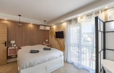 a bedroom with a bed and a large window at Les YUCCAS - 2 pièces Suquet Parking Vue Mer pour 4 personnes in Cannes