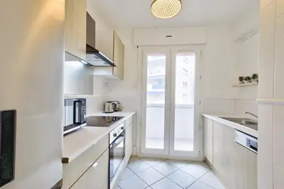 a kitchen with white counters and a window at T3 proche de la Croisette et Palais des Festivals in Cannes