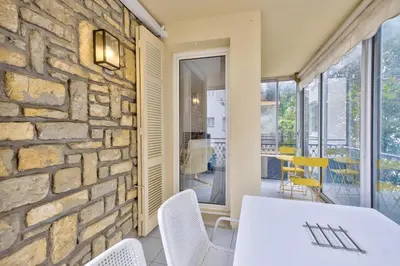a dining room with a stone wall and a white table and chairs at T3 proche de la Croisette et Palais des Festivals in Cannes