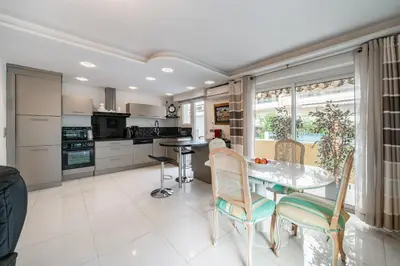 a kitchen and dining room with a table and chairs at 3 pièces au calme avec terrasses et verdure in Cannes