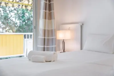 a white bedroom with a bed with towels on it at 3 pièces au calme avec terrasses et verdure in Cannes