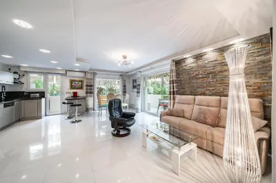 a living room with a couch and a brick wall at 3 pièces au calme avec terrasses et verdure in Cannes