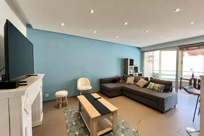 a living room with a couch and a blue wall at T2 apartment with terrace in Cannes in Cannes