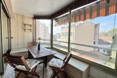 a balcony with a table and chairs and a window at T2 apartment with terrace in Cannes in Cannes
