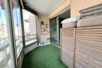 a room with a balcony with green carpet at T2 apartment with terrace in Cannes in Cannes