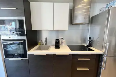 a kitchen with white cabinets and a sink at T2 apartment with terrace in Cannes in Cannes