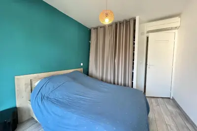 a bed in a room with a blue wall at T2 apartment with terrace in Cannes in Cannes