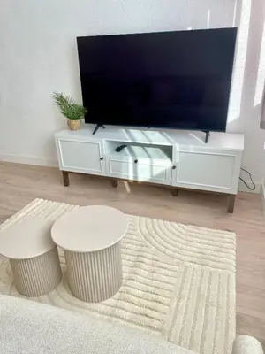 a living room with a tv and a white entertainment center at Cosy Studio Cannes in Cannes