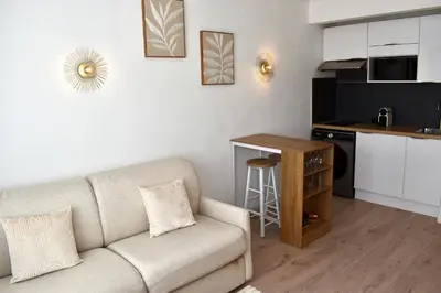 a living room with a couch and a kitchen at Cosy Studio Cannes in Cannes