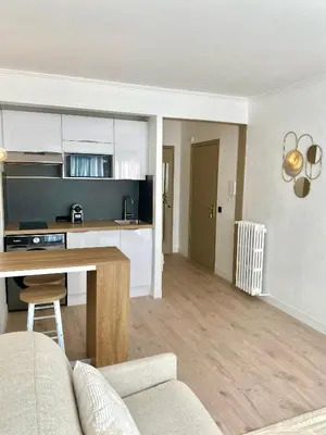 a living room and kitchen with a couch and a table at Cosy Studio Cannes in Cannes