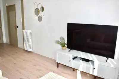 a living room with a large flat screen tv on a white cabinet at Cosy Studio Cannes in Cannes