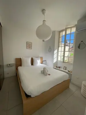 a bedroom with a large bed with a stuffed animal on it at Superbe 2P, clim, terrasse au calme, tout à pied in Cannes