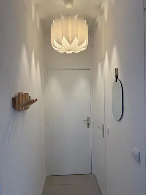 a hallway with a white door and a chandelier at Superbe 2P, clim, terrasse au calme, tout à pied in Cannes
