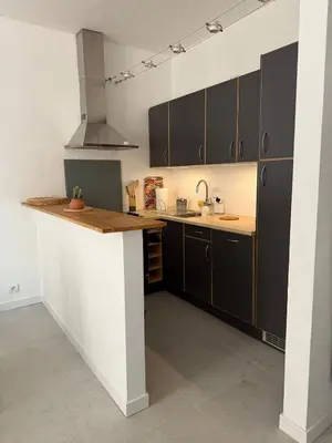 a kitchen with black and white cabinets and a counter at Superbe 2P, clim, terrasse au calme, tout à pied in Cannes