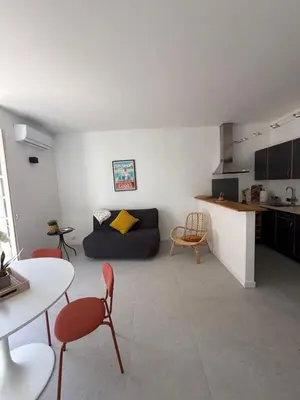 a living room with a couch and a table at Superbe 2P, clim, terrasse au calme, tout à pied in Cannes