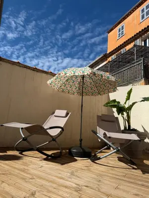 two chairs and an umbrella on a patio at Superbe 2P, clim, terrasse au calme, tout à pied in Cannes