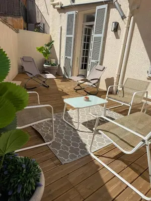 a patio with chairs and a table on a deck at Superbe 2P, clim, terrasse au calme, tout à pied in Cannes
