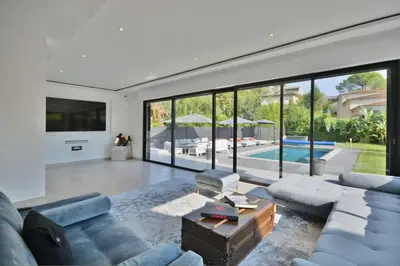 a living room with a couch and a table and a pool at Villa Bella Vista - Luxe - Piscine et Sérénité au Cœur du Cannet in Le Cannet
