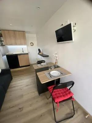 a living room with a table and a red chair at Studio cosy Cannes à 250 m de la plage, pointe Croisette in Cannes