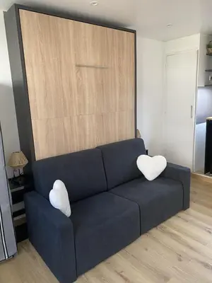 a blue couch with two white pillows in a living room at Studio cosy Cannes à 250 m de la plage, pointe Croisette in Cannes