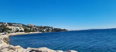 a large body of water next to a beach at Palm beach apartment with swimming pool in a residence in Cannes